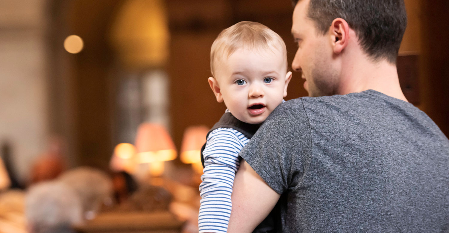 Baby carried by father during service at St Bride's