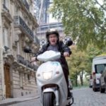 Journalist James Gillespie on motor scooter in Paris