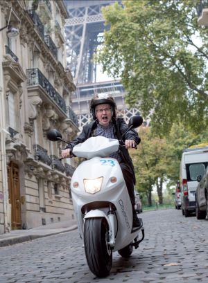 Journalist James Gillespie on motor scooter in Paris