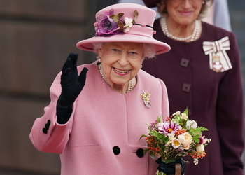 The Queen waving to crowds wearing pink