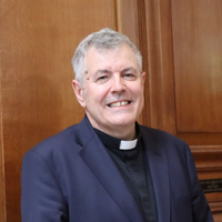 The Revd Steve Morris standing in front of St Bride's wooden panels