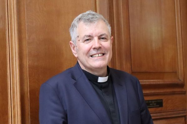 The Revd Steve Morris standing in front of St Bride's wooden panels