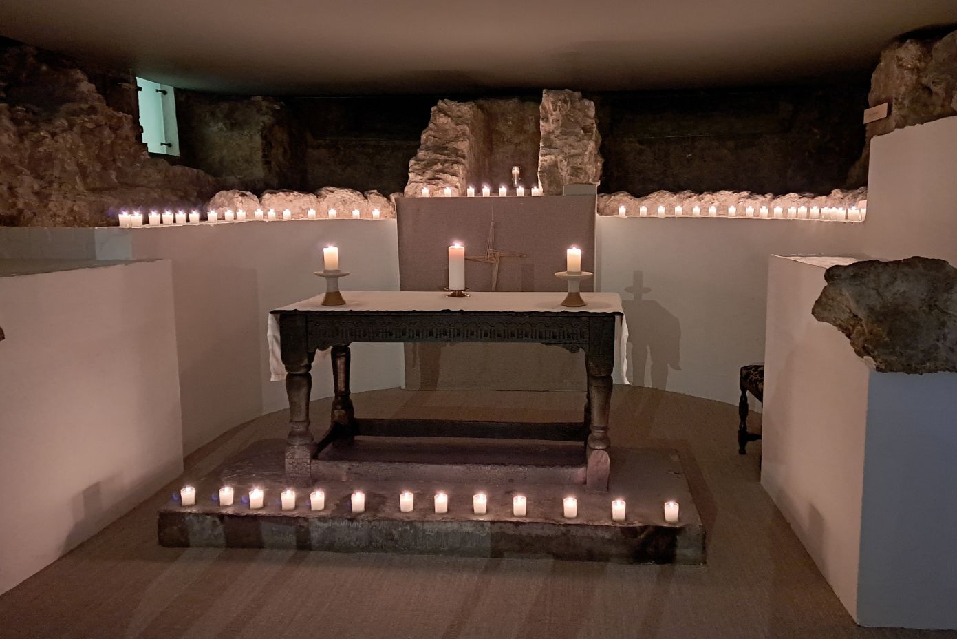 candles burning on the Crypt altar at St Bride's and the surrounding ancient walls